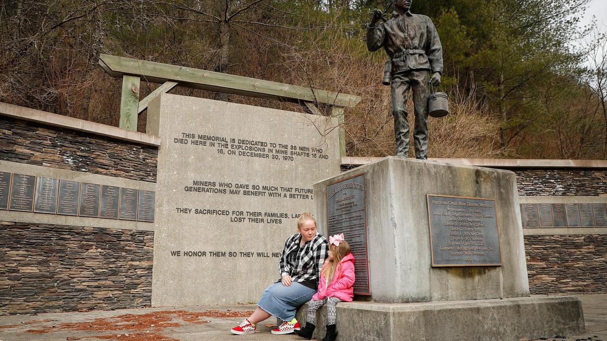 Kenna Napier, 16, left, and Aubrey Couch 3, both of Manchester, Ky., sit and talk on the base of the Hurricane Creek Mine Disaster Memorial in Hyden, Ky., Wednesday, Dec. 30, 2020. Hyden was recently named the state’s 27th “trail town.”