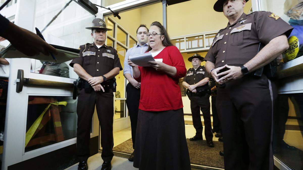 Rowan County Clerk Kim Davis with son Nathan Davis read a statement to the press outside the Rowan County Courthouse in Morehead on Sept. 14, 2015.  She announced that her office will issue marriage licenses under order of a federal judge, but the licenses will not have her name or office listed. Davis spent five days in jail for refusing to issue marriage licenses to same-sex couples.