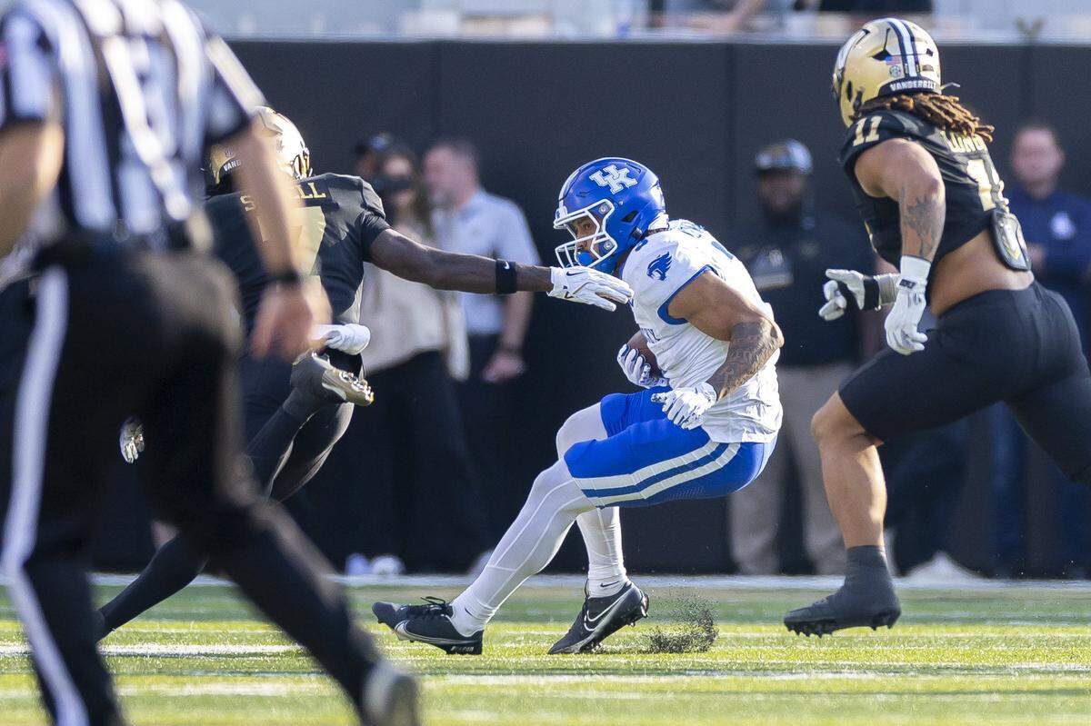 Kentucky running back Seth McGowan (3) runs the ball as Vanderbilt safety Marlen Sewell (7) and linebacker Bryan Longwell (11) pursue during Saturday’s game at FirstBank Stadium in Nashville, Tennessee.