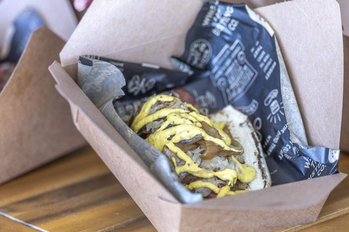 The Luscher Dog includes a pilsner-poached local bratwurst, grilled onions, sauerkraut and a three-mustard blend at Whiskey Thief Distilling Co. in Frankfort, Ky., on Thursday, May 7, 2026.