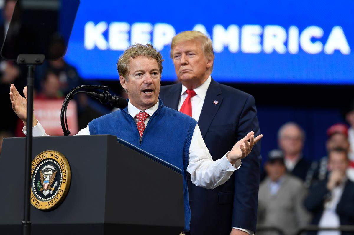 President Donald Trump listens as Sen. Rand Paul, R-Ky., speaks Monday during a campaign rally in at Rupp Arena.