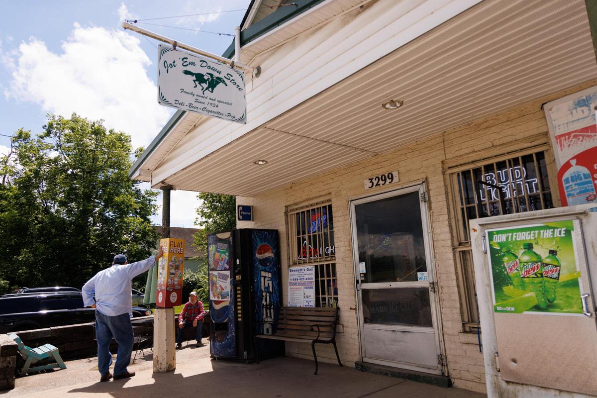 Patrons hang out on the front porch on Friday, May 27, 2022, at the Jot-Em Down Store in Lexington. Over the years the little store has drawn a notable crowd from politicians to movie stars.