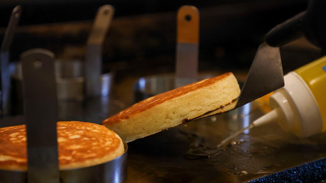 Beau’s Cafe chef and co-owner Spencer Sirles puts down some clarified butter as he cooks the flip side of an order of Buttermilk Pancakes, Oct. 9, 2024 at Beau’s Cafe in Lexington, Ky. The pancakes are first cooked using a mold to help them rise and keep their shape.