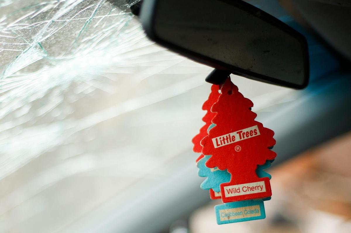 Little Trees air fresheners hang from the rear view mirror of a Hyundai Elantra with a cracked windshield parked near a destroyed home on North 5th Street in Mayfield, Ky.