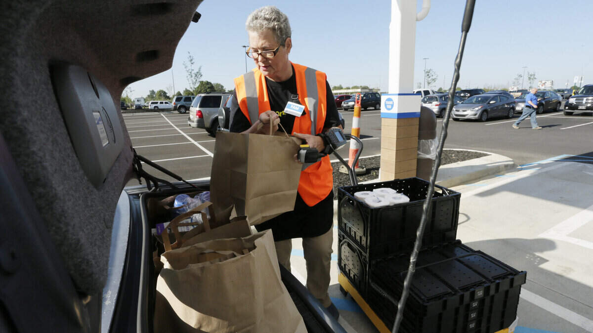 Pam Morgan loaded up a customer's trunk with groceries bought online at Kroger in Versailles, Ky., on Aug. 27, 2015. The Versailles Kroger is one of the first stores to have online ordering in the country.  Photo by Pablo Alcala | Staff