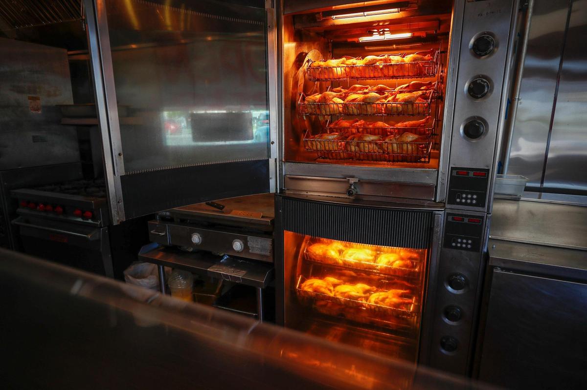 Seasoned chickens cook for about an hour and a half before they are prepared and served at Rosticeria Doña Coco. Each chicken is injected with garlic butter and seasoned with olive oil, ginger, salt, pepper and paprika before roasting.