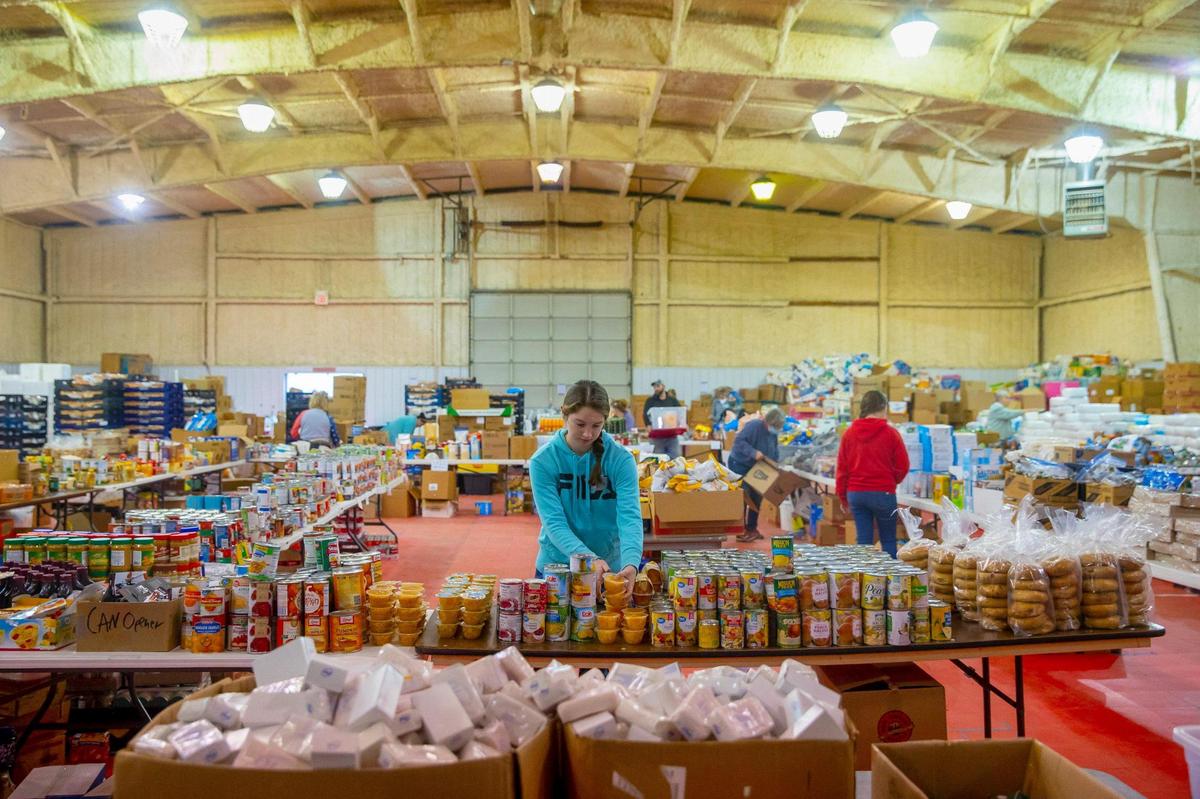 Callie Douglas of Graves County helps sort food at the Mayfield-Graves County Fairgrounds in Mayfield, Ky., on Monday, Dec. 20, 2021, for those impacted by a tornado that struck the community earlier in the month.