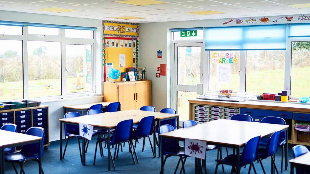 Tidy tables and chairs arranged in school class room, ready for pupils to arrive. Stock photo.