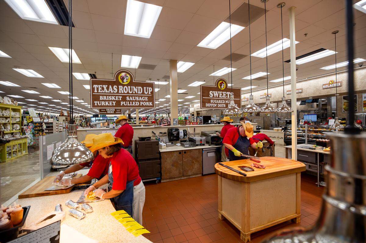 Workers prepare barbecue and other hot food items for the Texas Round Up inside a Buc-ee’s. The Texas-based travel center chain is opening its first location in Richmond.
