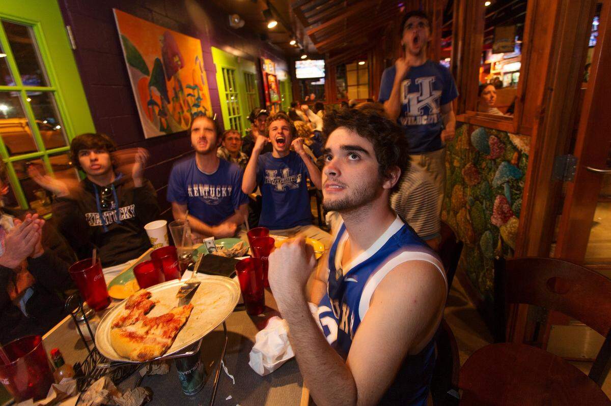 Tates Creek High School senior Ben Childress, center, watches the game with his friends at Mellow Mushroom as UK defeated Wisconsin, 74-73 for a spot in the 2014 NCAA Championship game against Connecticut , Saturday, April 05, 2014 at bars near campus in Lexington. Photo by Jonathan Palmer