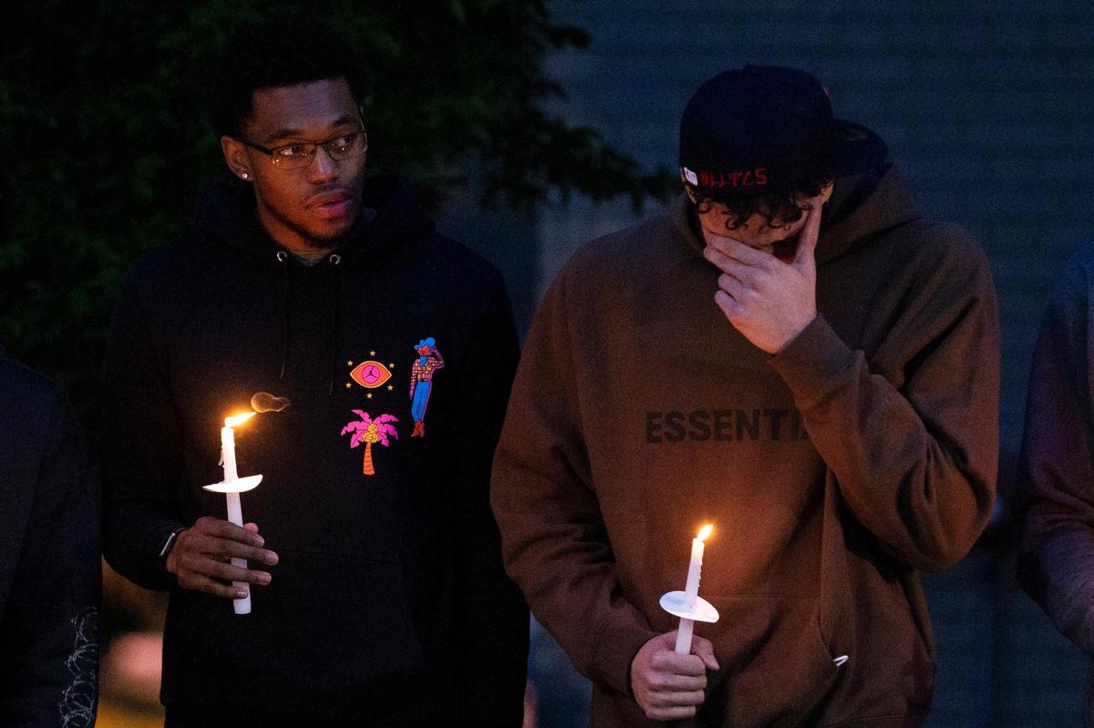Kentucky basketball player Lance Ware, right, wipes tears from his eyes as he and Keion Brooks, Jr. hold candles during the vigil for former UK basketball player Terrence Clarke on the University of Kentucky campus in Lexington, Ky., on Friday, April 23, 2021.
