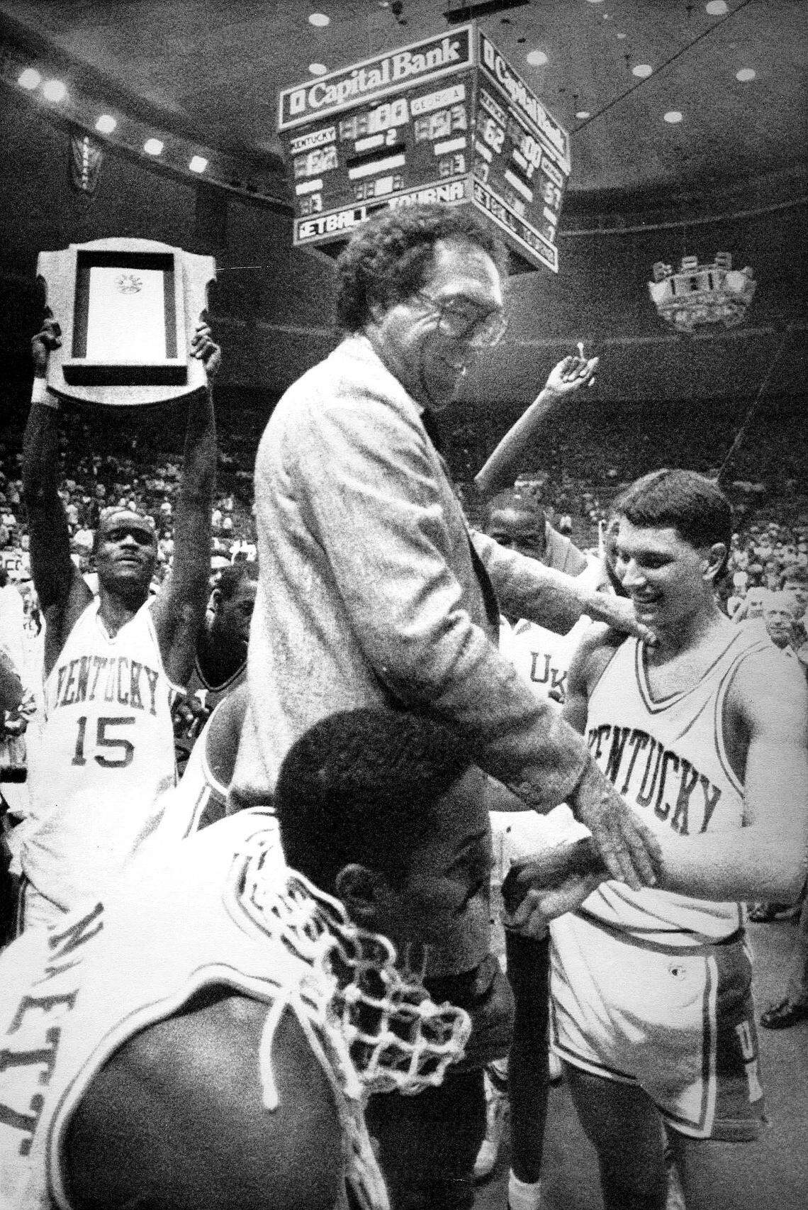 Ed Davender, left, held the trophy as University of Kentucky coach Eddie Sutton, Rex Chapman and Winston Bennett celebrated after the team won the SEC Tournament in 1988.