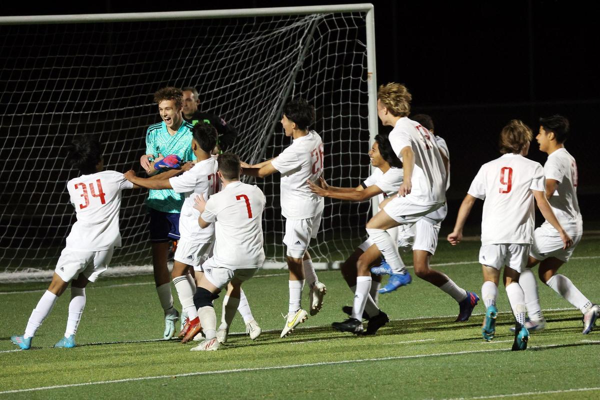Paul Laurence Dunbar goalkeeper Mason Feddock is swarmed by his teammates as the Bulldogs celebrate winning the KHSAA boys’ soccer state championship last fall. Dunbar enters 2023 seeking its third consecutive state title.