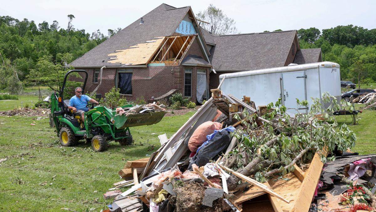 Ken Likins hauls debris to the curb from a damaged home on Cedar Ridge Drive in the Crooked Creek neighborhood east of London, Ky., Sunday, May 18, 2025. Likins said he was friends with the homeowner and lived across the street. Two days earlier, thunderstorms and a deadly tornado ripped through the Laurel County, destroying many homes.
