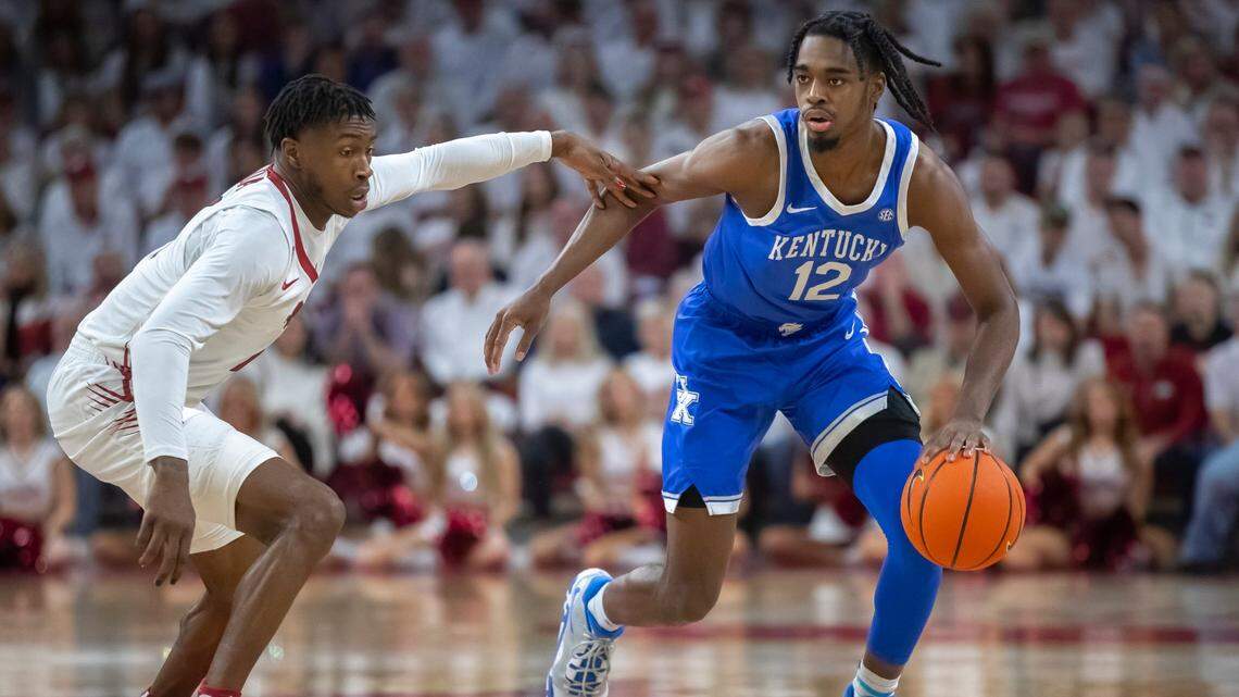 Kentucky Wildcats guard Antonio Reeves (12) drives the ball as Arkansas Razorbacks guard Davonte Davis (4) plays defense during a game at Bud Walton Arena in Fayetteville, Ark., on Saturday, March 4, 2023.