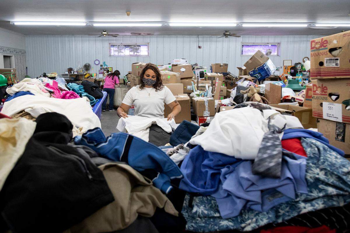 Jodii Gayheart folds clothes that were donated at the Methodist Mountain Mission warehouse in Jackson, Ky., Thursday, June 25, 2020.