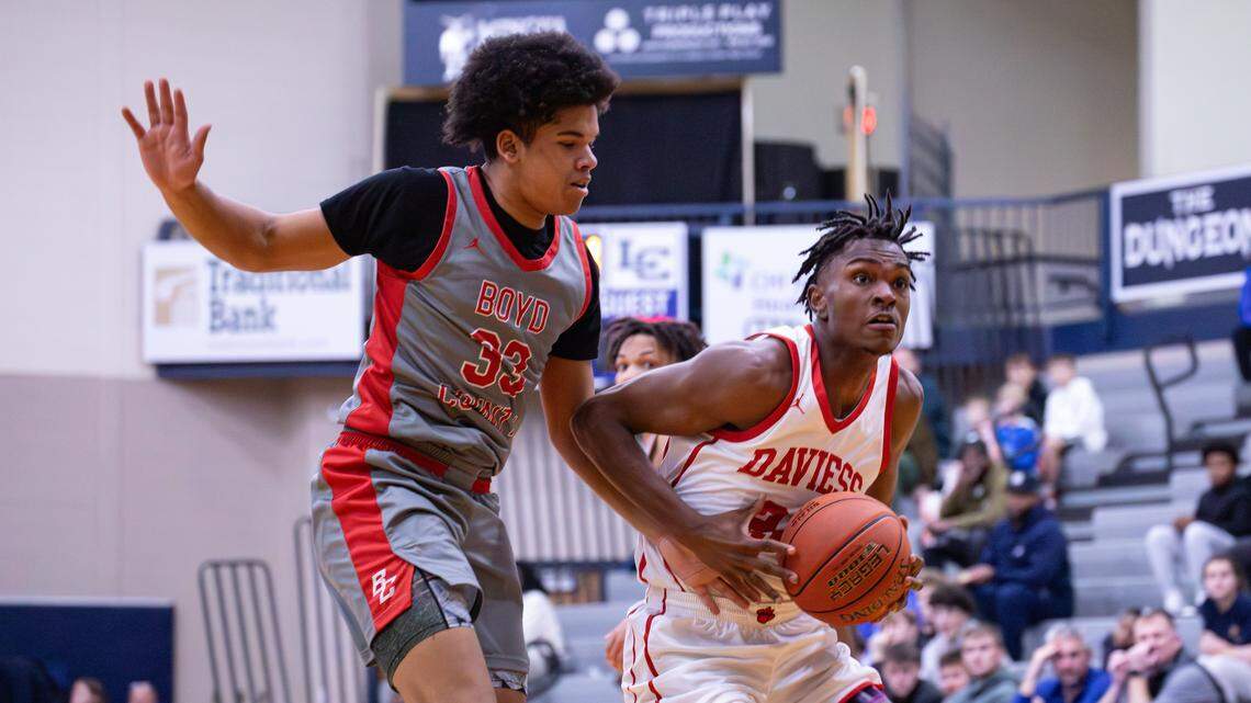Daviess County's DeAaron Watkins (24) pressing past Boyd County's Caleb Rimmer (33) for two points during the White, Greer & Maggard Holiday Classic championship game on Dec. 30, 2025, in Lexington, Ky.