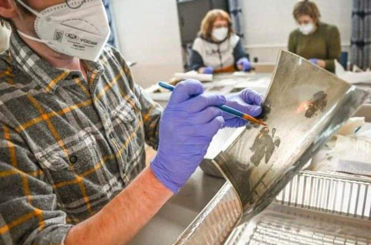 A volunteer at Hindman Settlement School works to restore a photograph following flooding in Eastern Kentucky in 2022. The University of Kentucky, along with several other agencies, have formed the Kentucky Heritage Emergency Response Network to help preserve art following natural disasters.