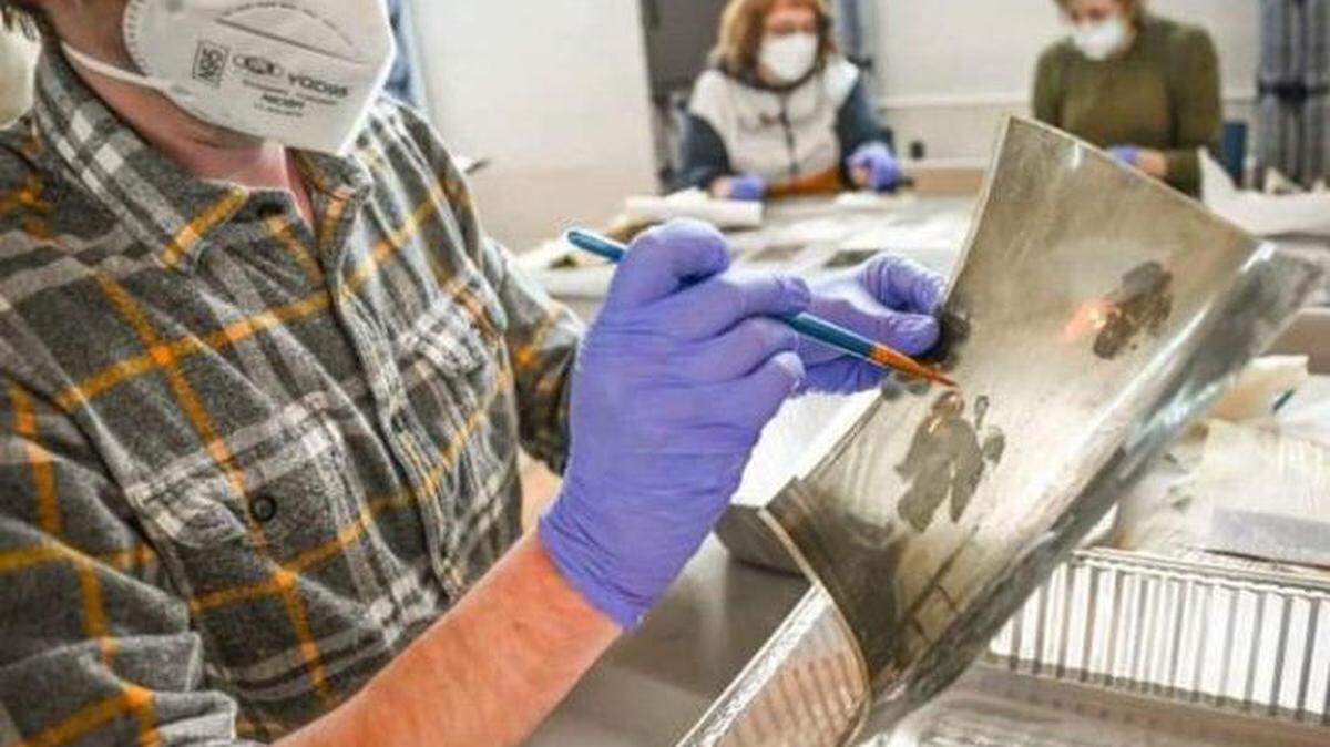 A volunteer at Hindman Settlement School works to restore a photograph following flooding in Eastern Kentucky in 2022. The University of Kentucky, along with several other agencies, have formed the Kentucky Heritage Emergency Response Network to help preserve art following natural disasters.