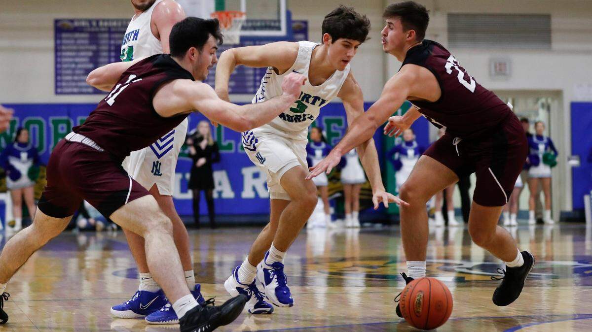 North Laurel’s Reed Sheppard (3) dribbles through the defense of Pulaski County’s Zach Travis (11) and Caleb Sloan (23) in London, Ky., on Feb. 8.