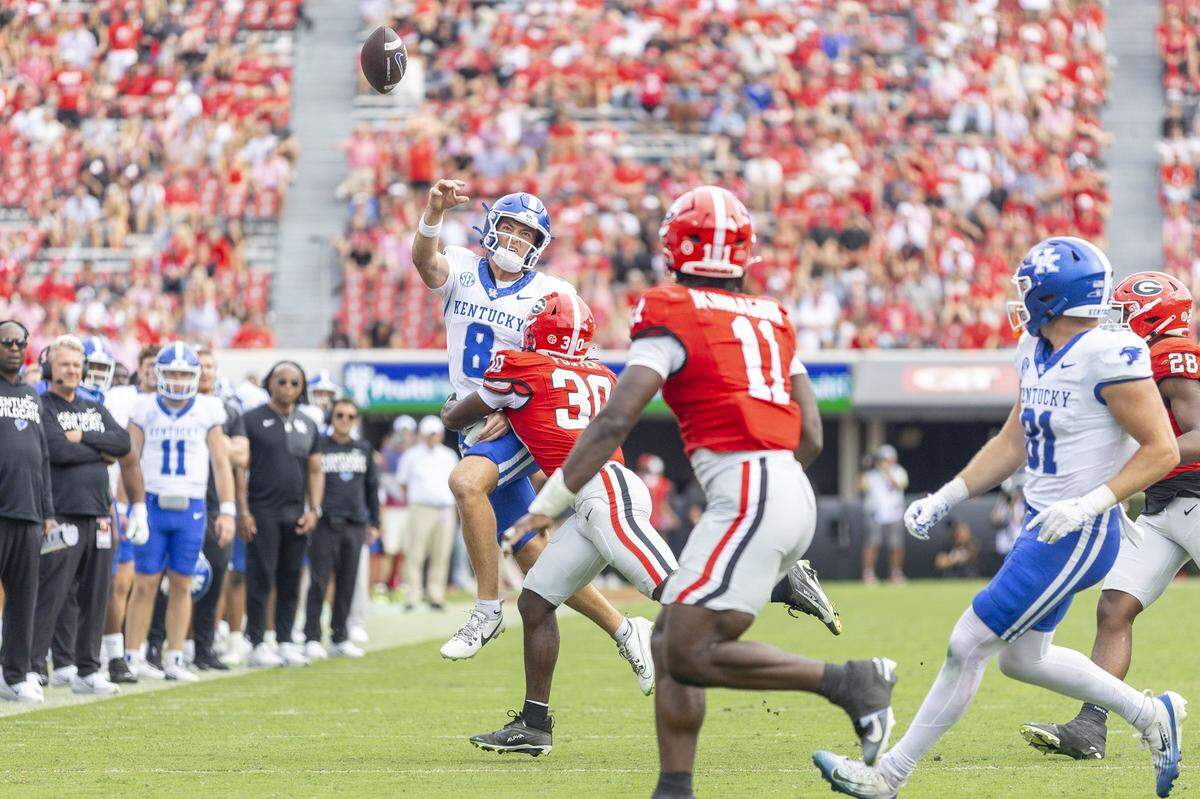 Kentucky Wildcats quarterback Cutter Boley (8) passes the ball as he’s pressured by Georgia Bulldogs linebacker Terrell Foster (30) during a game at Sanford Stadium in Athens, Ga., on Saturday, Oct. 4, 2025. 