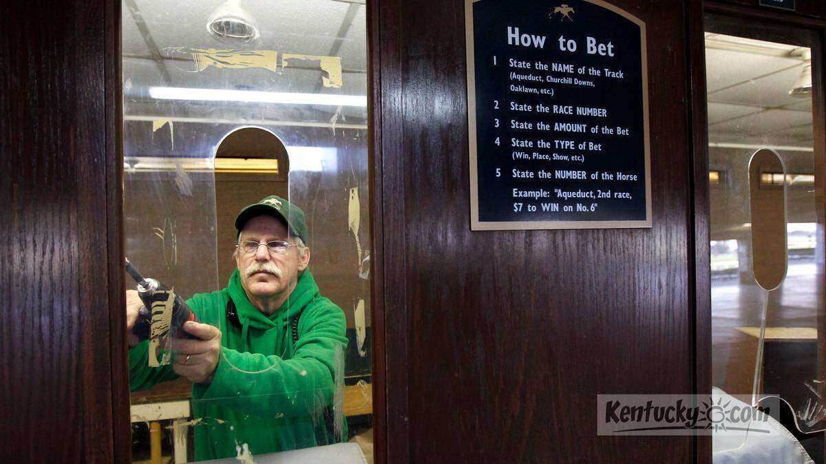 Garrett Cobb screwed in plastic weather shields in the betting windows ahead of the opening of Keeneland's 2012 fall meet. Cobb said the shields were being installed because of the forecast of cooler weather on opening weekend. He said they would take the shields out as soon as it warms up.  Photo by Charles Bertram | Staff