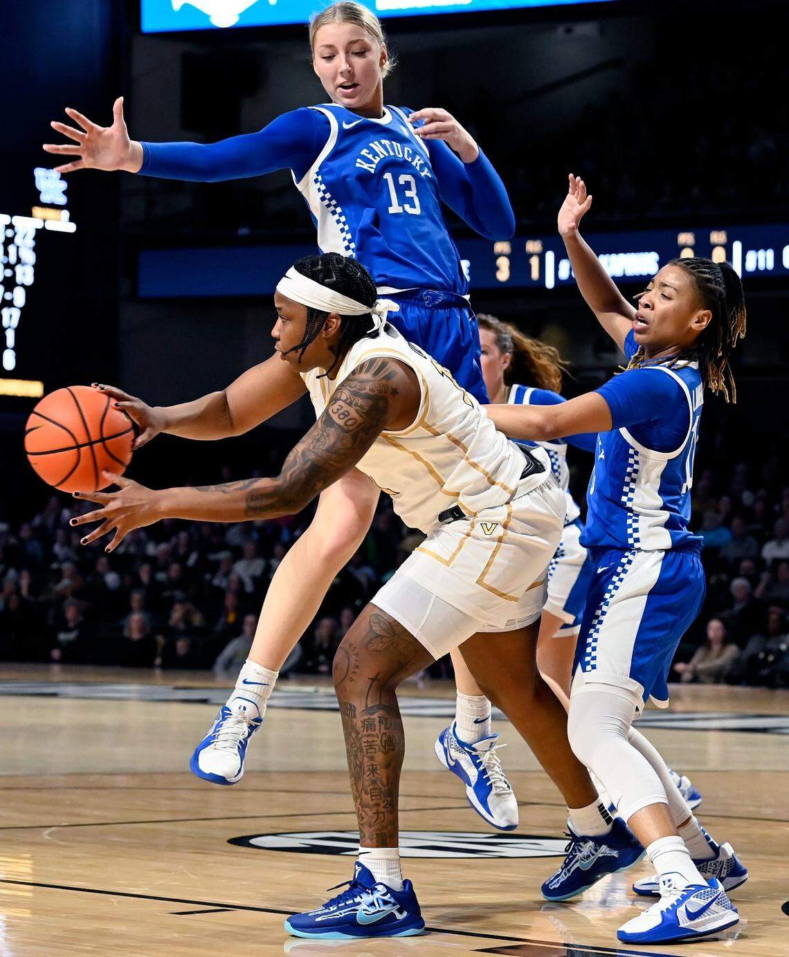 Vanderbilt guard Jordyn Oliver (11) passes the ball as Kentucky's Clara Strack (13) and Dazia Lawrence (10) defend during an NCAA college basketball game Sunday, Jan. 5, 2025, in Nashville, Tenn.