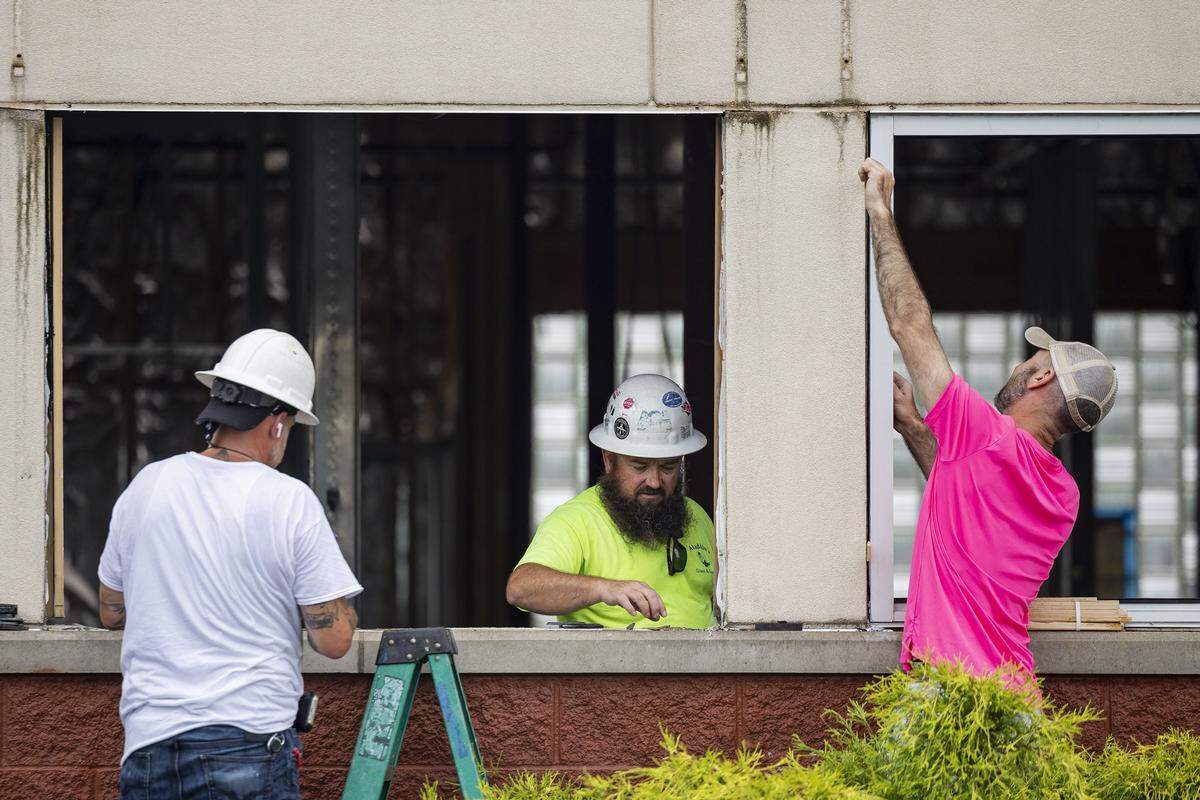 Levi Jolly, left, Jeremy Mallet, center, and another worker from Aladdin’s Glass, remove the frame from a window during construction of a new dispensary on Wednesday, July 9, 2025, at the old Frisch's Big Boy in Hamburg in Lexington, Ky.