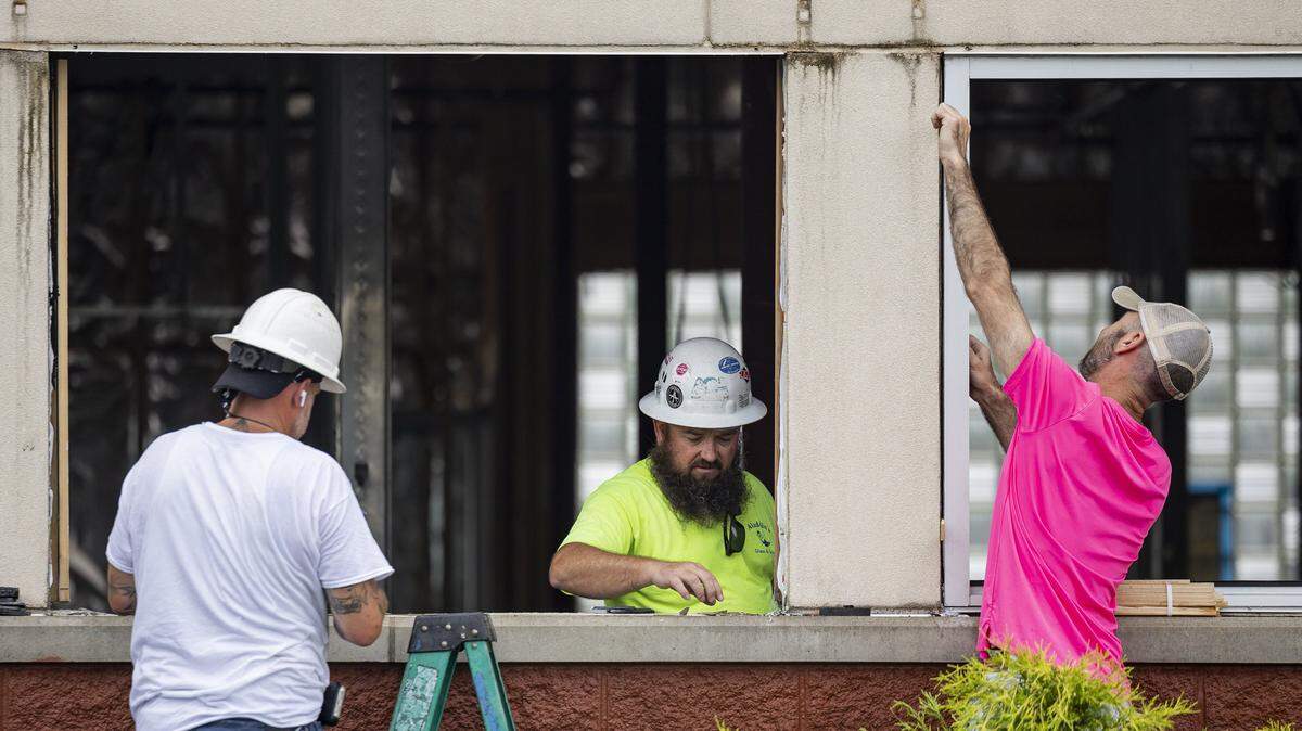 Levi Jolly, left, Jeremy Mallet, center, and another worker from Aladdin’s Glass, remove the frame from a window during construction of a new dispensary on Wednesday, July 9, 2025, at the old Frisch's Big Boy in Hamburg in Lexington, Ky.