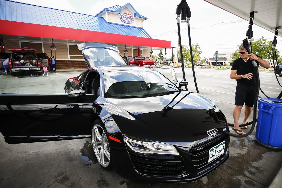 Tony DeMarco, of Denver, worked to vacuum his 2014 Audi R8 at following an automated wash and wax Time to Shine car wash Wednesday in Lexington.