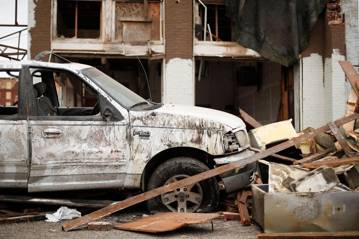 A destroyed Ford F-150 pick-up sits amongst building debris along West Broadway Street in Mayfield.