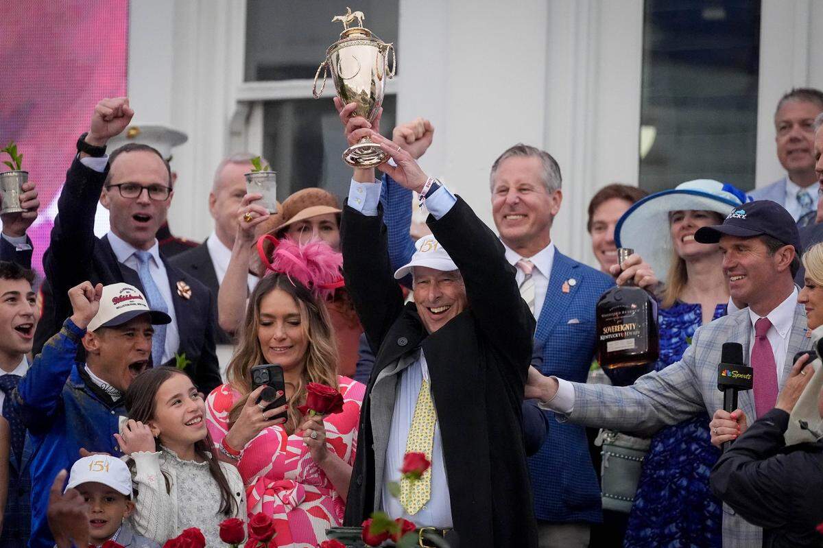 Michael Banahan, Sovereignty’s ownership representative, hoists the trophy after 151st Kentucky Derby at Churchill Downs.