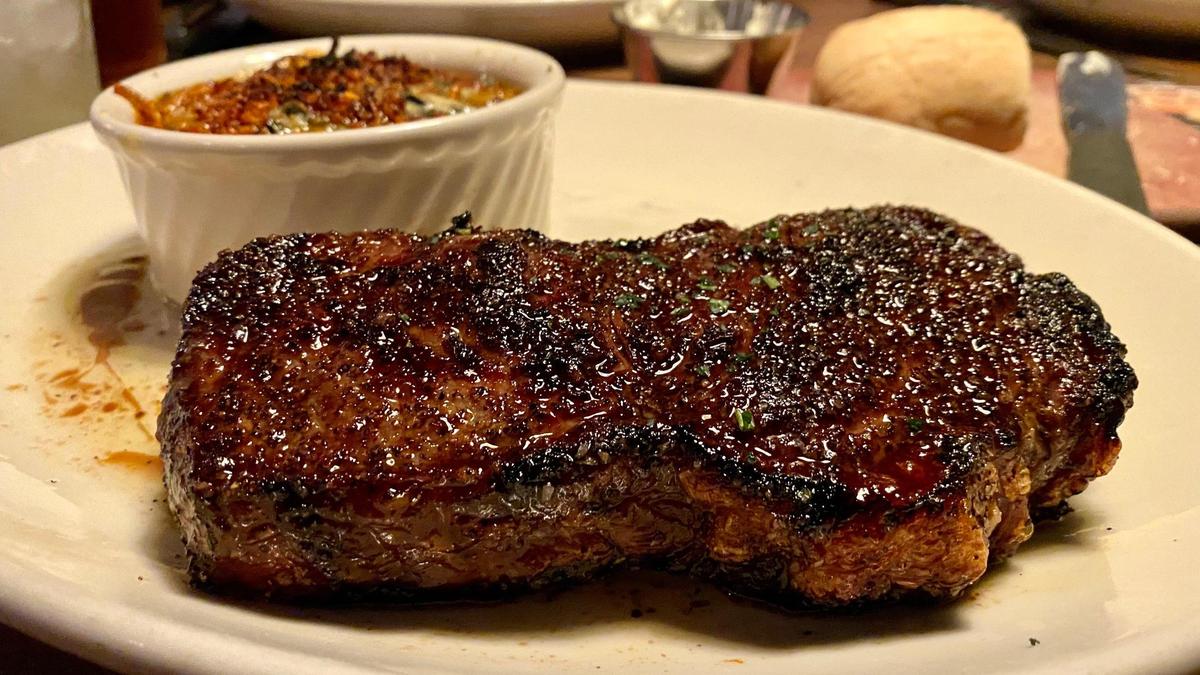 A 14 oz. prime center cut New York strip steak ($63.99) with a side of creamed spinach au gratin at Malone’s Lansdowne location.