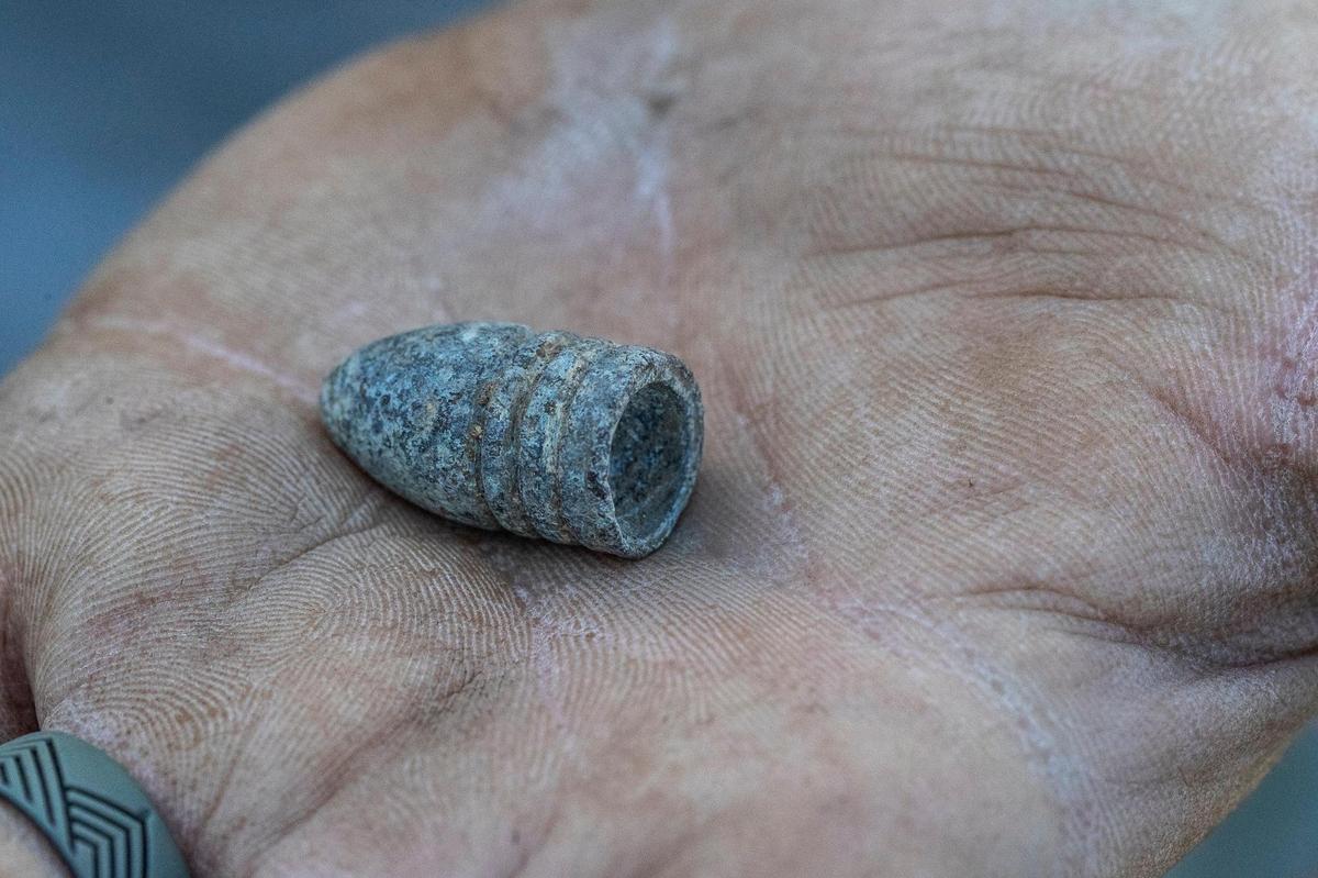 Jason Flay, an archaeologist at Acheulean Consulting, holds a Mini Ž ball bullet discovered under Triangle Park in Lexington. Crews working on the new Town Branch Commons trail through downtown Lexington have uncovered several archaeological finds, including early stone tools that likely predate European settlement in 1775.