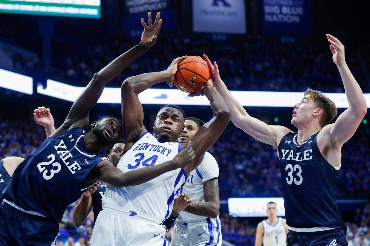 Kentucky forward Oscar Tshiebwe (34) gets a rebound against Yale forwards Yussif Basa-Ama (23) and Jack Molloy (33) during Saturday’s game at Rupp Arena.