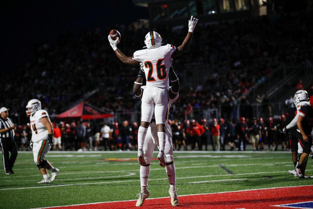 Davaun Hart (26) of Frederick Douglass got a lift from a teammate after scoring a touchdown Friday night.