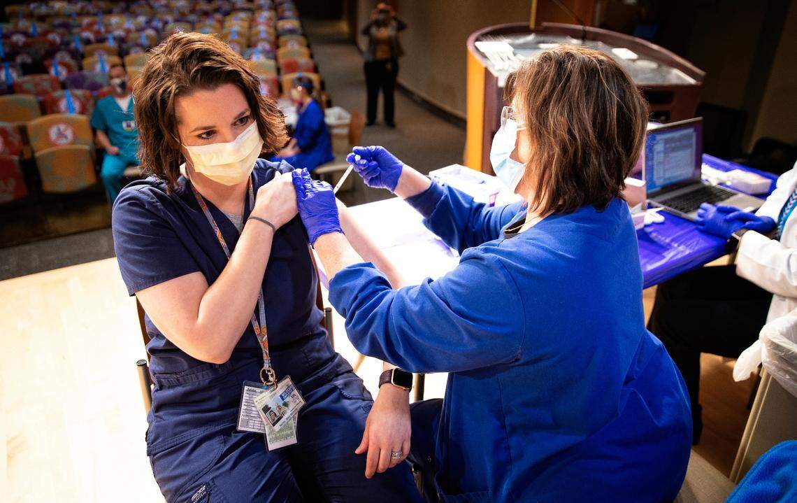 Abby Bailey, Emergency medicine pharmacist gets her vaccination from UK Health services nurse Janie Lawson, RN, as UK administered its first round of Covid-19 vaccine on December 15, 2020. Photo by Mark Cornelison | UKphoto