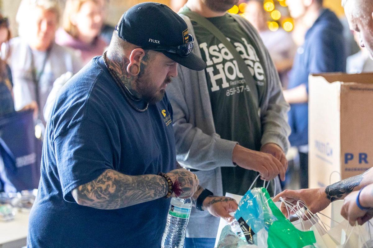 Odell Scott Hager adds bottled water to a hygiene and necessity bag at the Recovery Cafe in Lexington, Ky., on Friday, April 18, 2025. Nearly 200 bags were prepared and distributed during Lexington Community Partner Street Outreach Day.