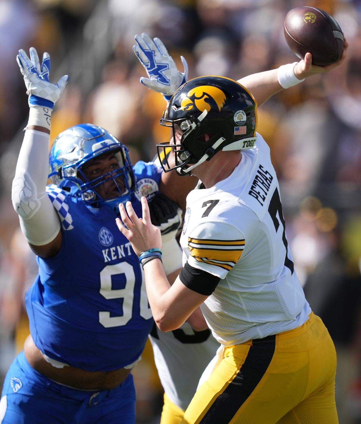 Jan 1, 2022; Orlando, FL, USA; Iowa Hawkeyes quarterback Spencer Petras (7) attempts a pass under pressure from Kentucky Wildcats defensive lineman Tre'vonn Rybka (90) during first half in the 2022 Citrus Bowl at Camping World Stadium. Mandatory Credit: Jasen Vinlove-USA TODAY Sports