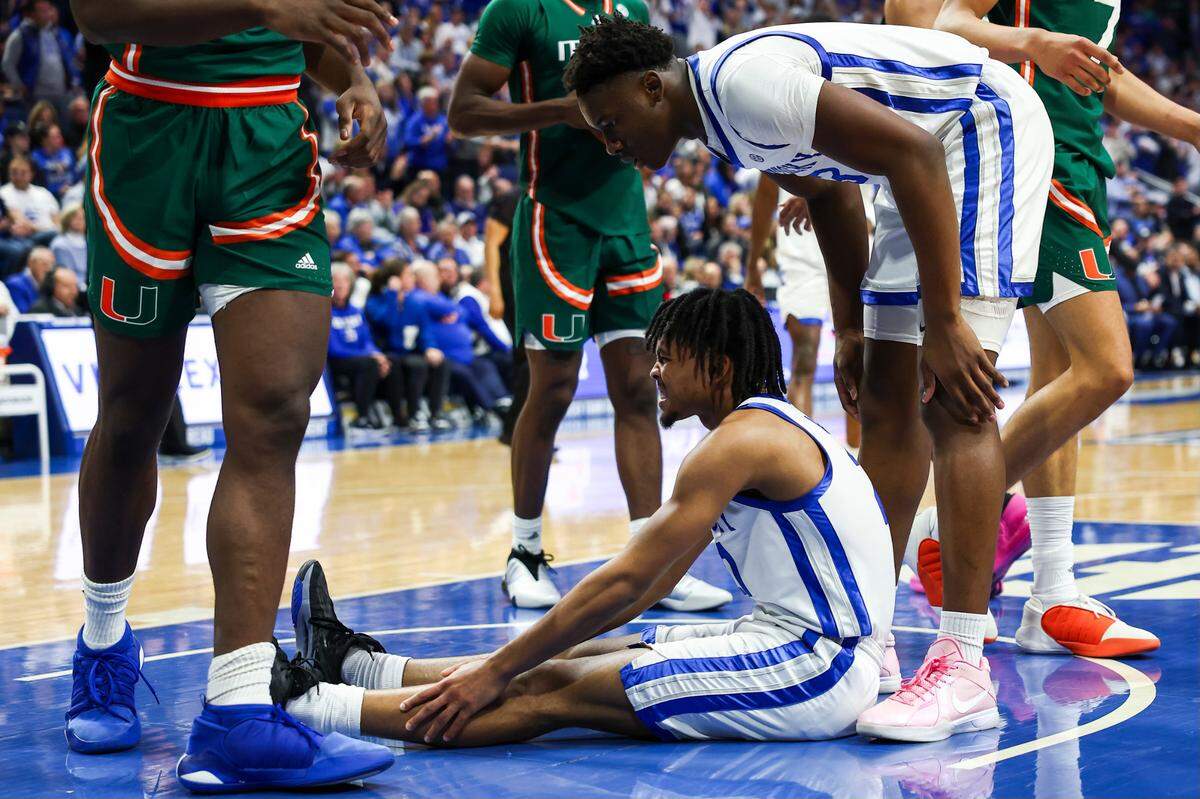 Kentucky Wildcats guard D.J. Wagner (21) rests holding his leg after being fouled by the Miami Hurricanes’s Wooga Poplar during the 2023 ACC/SEC Challenge game at Rupp Arena in Lexington, Ky, Tuesday, November 28, 2023.