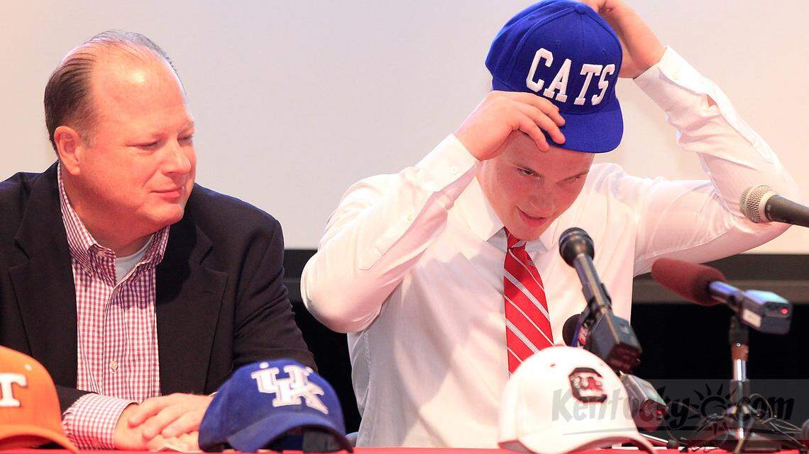 Conner High School quarterback Drew Barker, right with father, Terry Barker at left, put on a Cats hat to announce his commitment to the University of Kentucky during a press event Conner High School in Hebron, Ky., on May 10, 2013. Photo by Pablo Alcala | Staff 