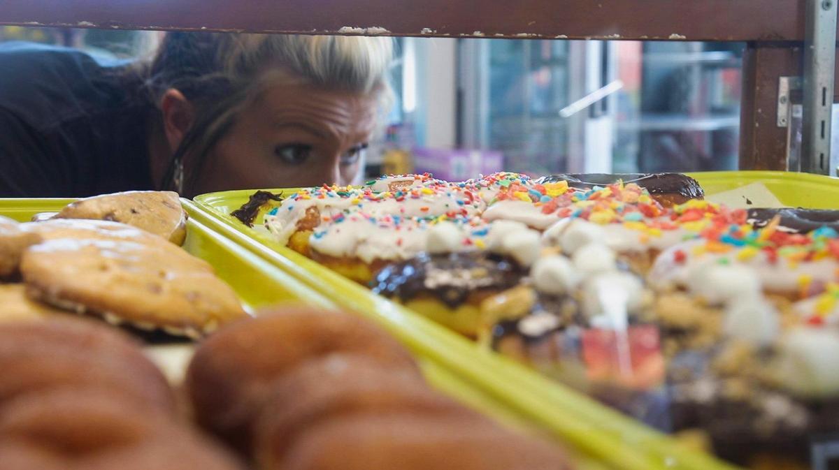 Assistant manager Laken Burchett prepares an order of doughnuts.. A top seller is a glazed croissant you can also get filled or unfilled.
