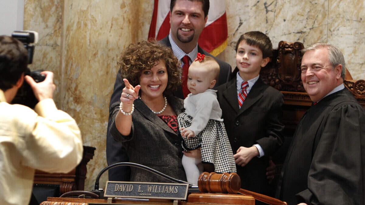 After the Senate swearing-in ceremony Tuesday, Kentucky Chief Justice John D. Minton Jr., right, posed with newly elected Sen. Jared Carpenter, R-Richmond; his wife, Erica; their 8-month-old daughter, Cate; and 5-year-old son, Cole.