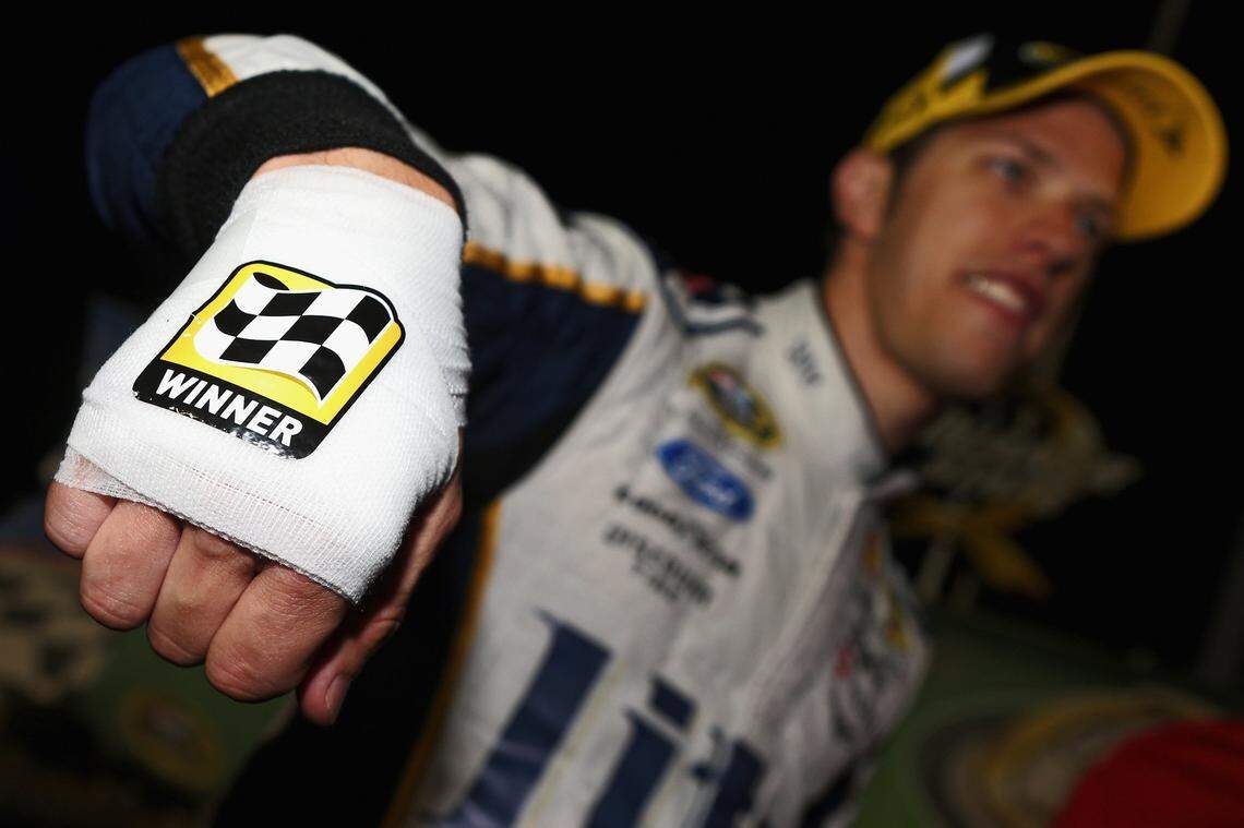 Brad Keselowski showed off his bandaged hand after needing four stitches to stop the bleeding after cutting himself while celebrating with champagne in Victory Lane after winning the 2014 Quaker State 400.