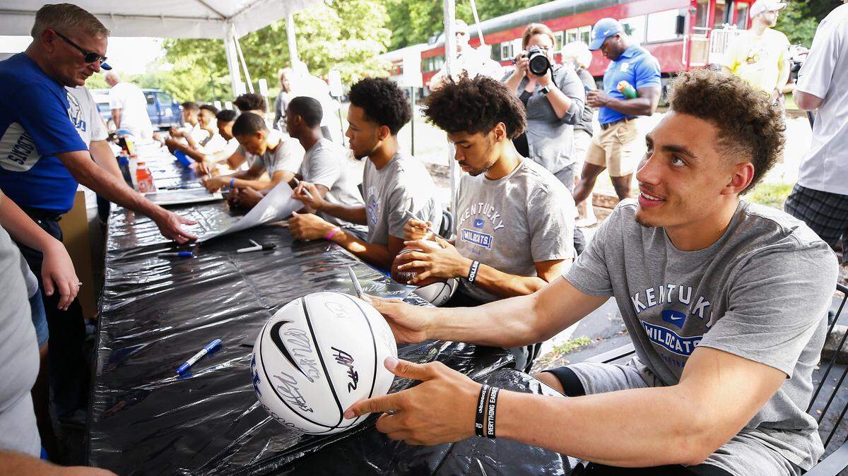 Incoming Kentucky senior forward Reid Travis, right, and other members of the team signed basketballs and other items for fans during a train stop as part of the Big Blue Caravan Sunday in Midway. The team has been able to practice this week.