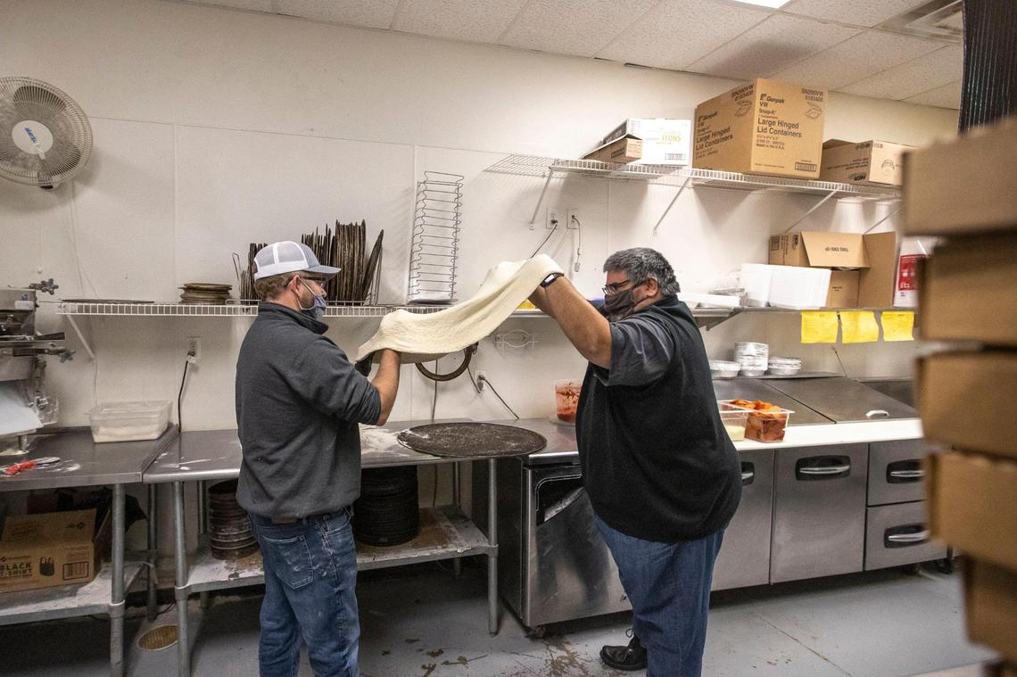 Curtis Gordon, left, and Johnny Hunt, stretch out the dough for a Big Bambino Jan. 21 at Big City Pizza in Lexington. The 28-inch-pizza is Lexington's largest.