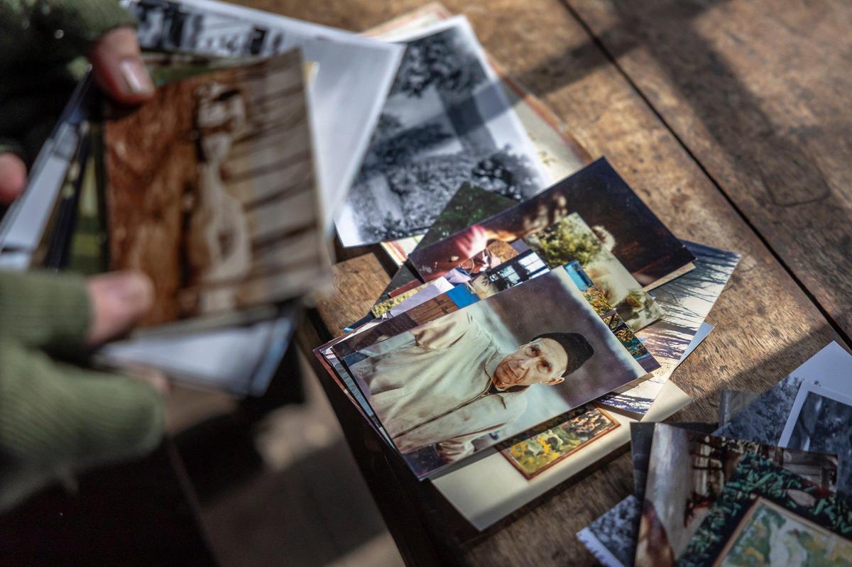 Joe Wolek, a founding member of Payne Hollow on the Ohio, sorts through old photographs of Payne Hollow in Trimble County, Ky., on Thursday, March 6, 2025. Hubbard lived with his wife, Anna, off their land in a very remote and sustainable way for about 40 years at Payne Hollow.