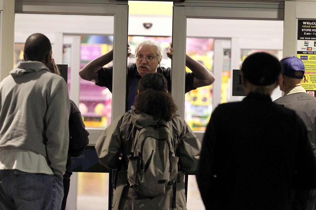 A Euclid Ave. Kroger employee notifies waiting customers that they will be limited to purchasing one pack of toilet paper as they waited for the store to open 7 a.m. Thursday.
