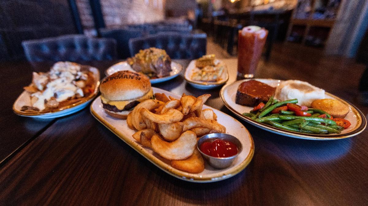 Nic & Norman’s restaurant, from the creators of “The Walking Dead,” is set to open downtown on Main Street. April 19, 2022. Clockwise from the left, the Philly cheese steak fries, the Coca-Cola braised pork, the avocado and crab toast, the Bloody Nicotero cocktail, the homestyle meatloaf, and the pimento bacon cheeseburger.