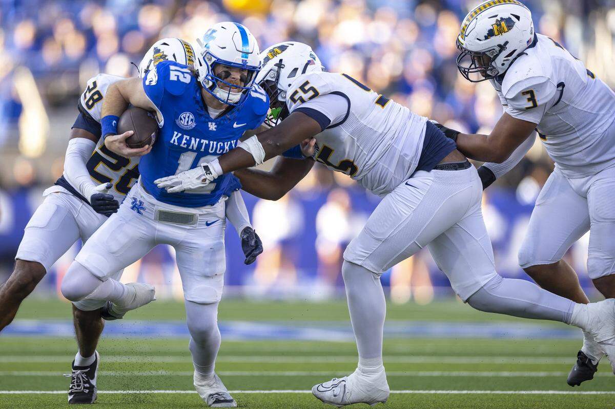 Kentucky quarterback Brock Vandagriff (12) is wrapped up by Murray State defensive back Esteban Guillory (28) and defensive lineman Miles Bailey (55) during Saturday’s game at Kroger Field.